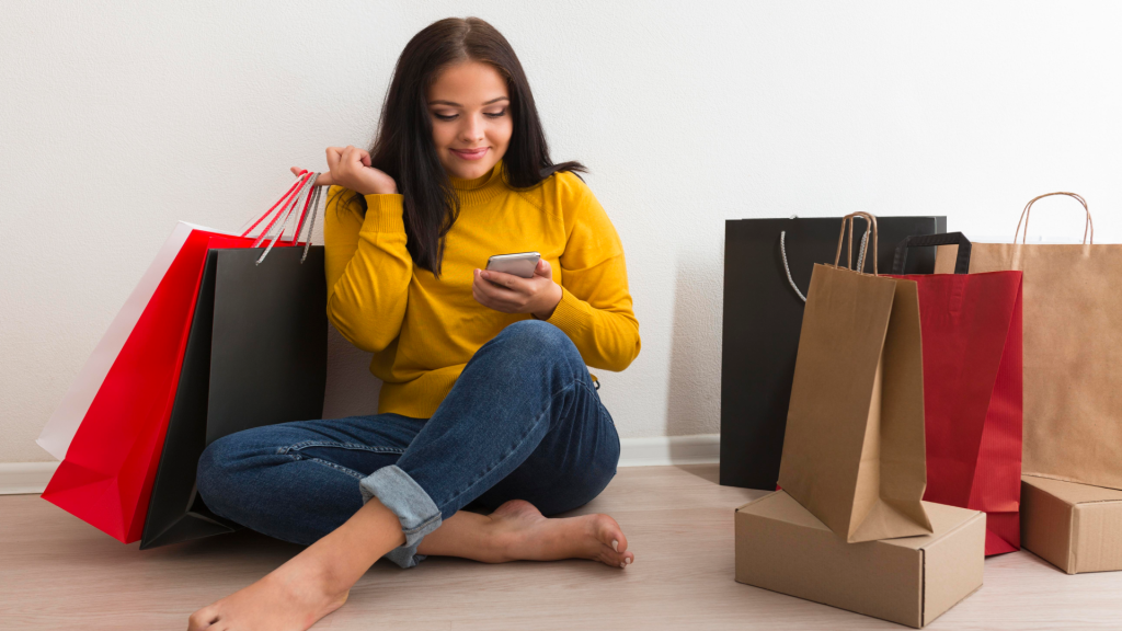 a-woman-sitting-shopping-bags browsing her phone